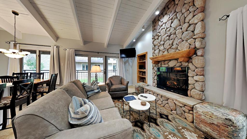 a living room with a large stone fireplace at Timberline Condominiums 3 Bedroom plus loft Deluxe Unit D3E in Snowmass Village