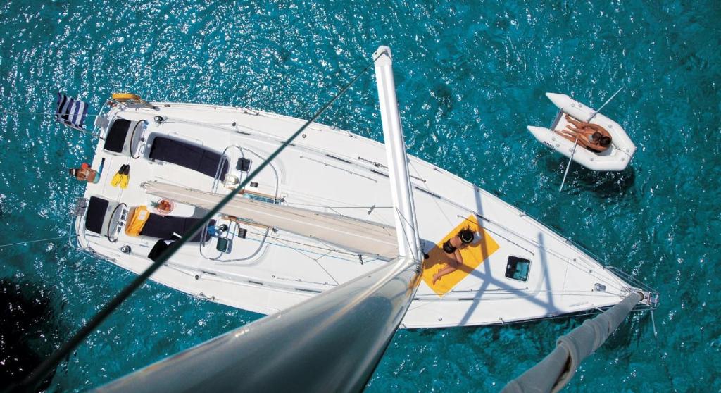 a white boat in the water next to a smaller boat at Dorfe Kotor Muo in Tivat