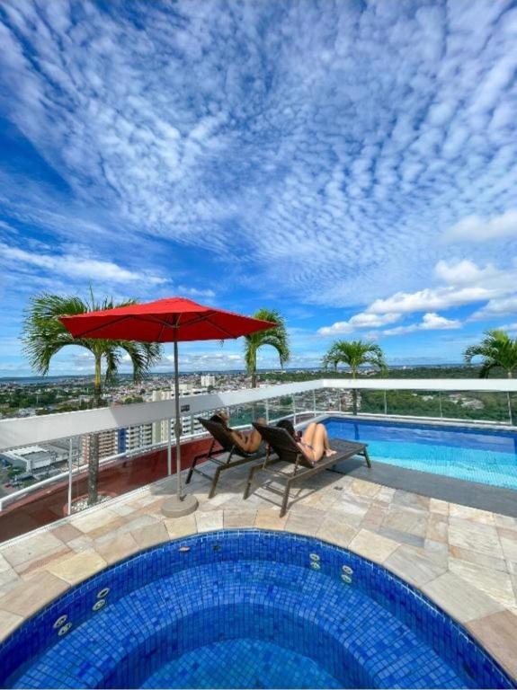 a woman laying on a chair next to a swimming pool at Flat no Hotel Millenium Manaus in Manaus