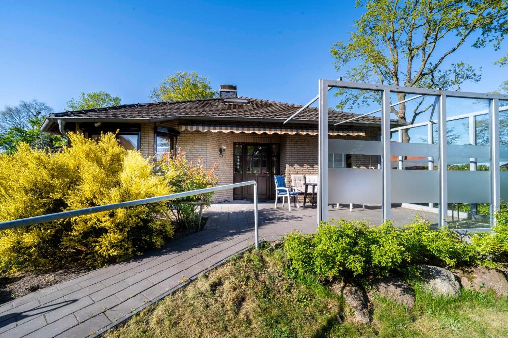 a home with a wooden deck and a house at Int Dörpe in Lengerich