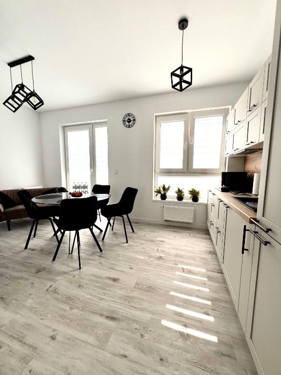 a kitchen and dining room with a table and chairs at Apartament Tosia in Chełm