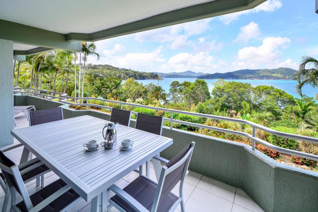 ハミルトン島にあるLagoon Apartments on Hamilton Island by HIHAの水辺の景色を望むバルコニーのテーブル