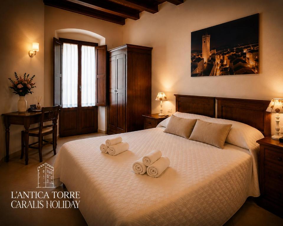 a bedroom with a bed with two towels on it at L'Antica Torre Caralis Holiday in Cagliari