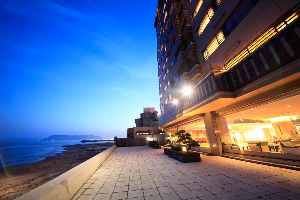 a building next to the ocean at night at Heiseikan Shiosaitei in Hakodate