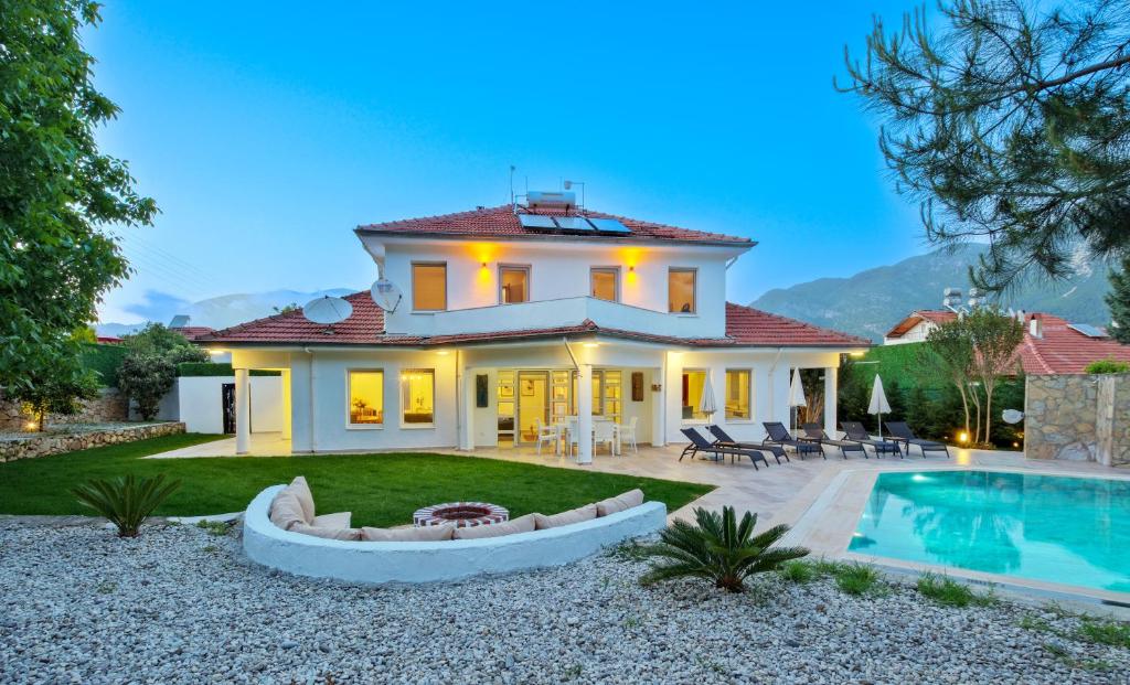 a villa with a swimming pool and a house at Villa Kısmet in Fethiye