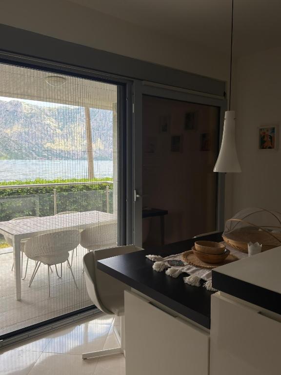 a kitchen with a large window and a table with chairs at Luxury Waterfront Apartment in Boka Bay, Stollywood in Donji Stoliv