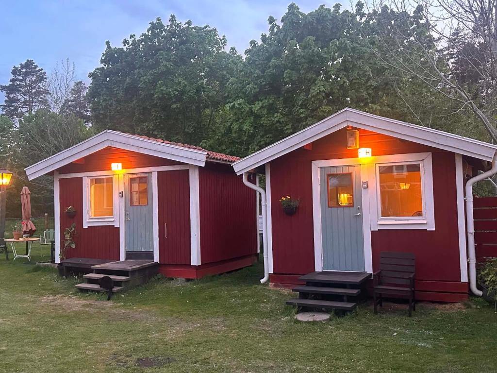 two red tiny houses with lights on them at Daltorps skola, Övernattningsstuga H, Self check in, Übernachtungskabine H in Skövde
