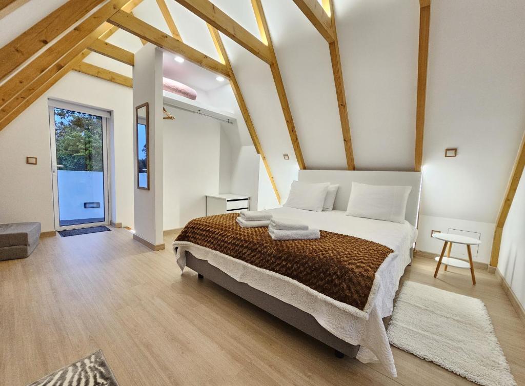 a bedroom with a large bed in a room with wooden beams at Celeiro do Avô in Santana