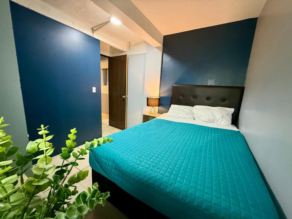 a blue bedroom with a bed with a blue wall at R&A Hostal in Mexico City
