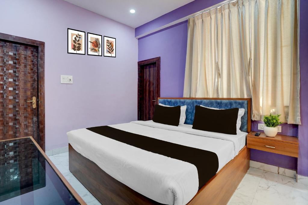 a bedroom with a large bed with purple walls at Hotel O Regal Retreat in Rānchī