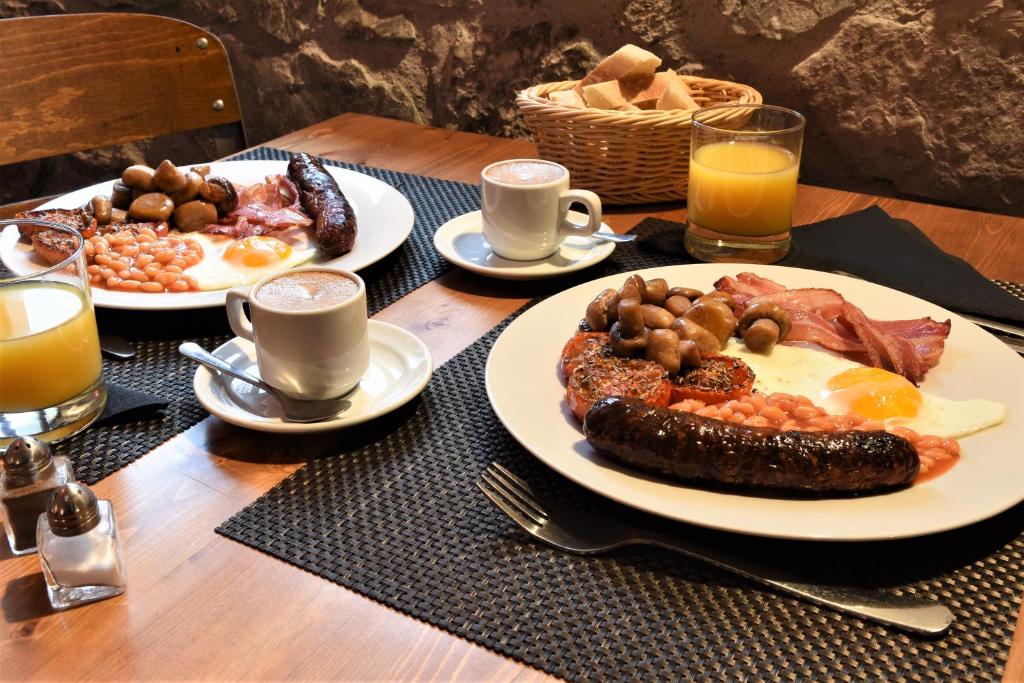 a table with two plates of breakfast food on it at Glamping at Camping La Source in Saint-Pierre-dʼArgençon