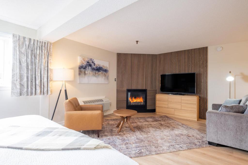 a hotel room with a bed and a fireplace at Fireside Inn & Suites Waterville in Waterville