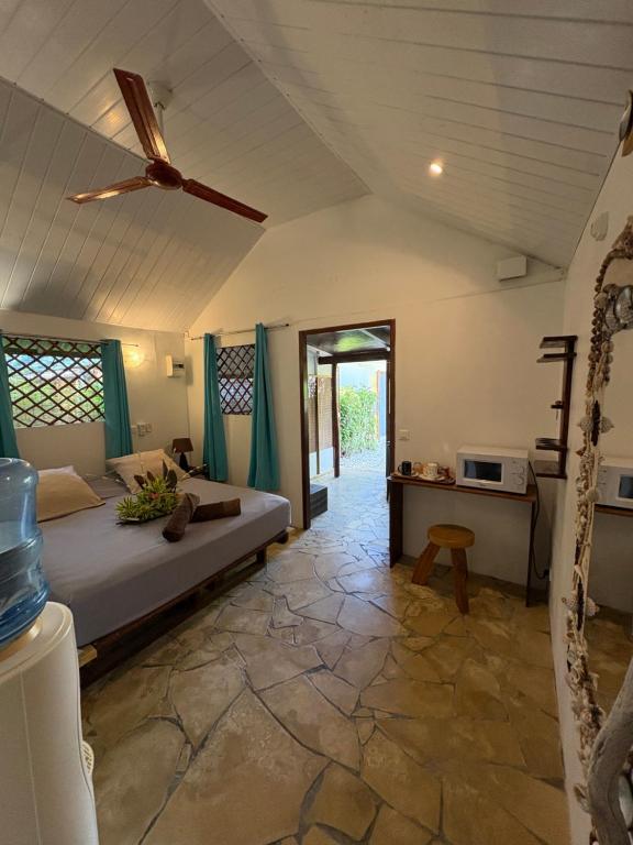 a bedroom with a bed and a ceiling fan at Poe Guesthouse in Avatoru
