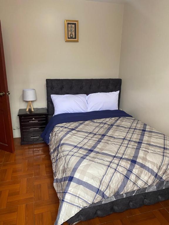 a bedroom with a bed with a blue and white comforter at El refugio de Lolita, tu hogar en Loja in Loja