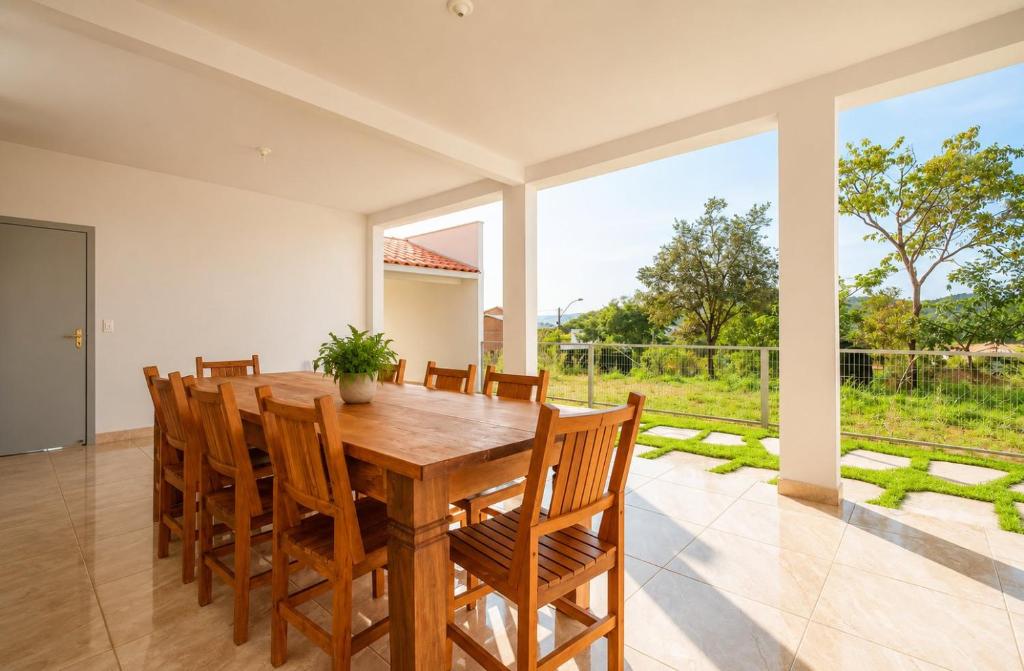 a dining room with a wooden table and chairs at Quinta do Sol Condominium - Pirenópolis in Pirenópolis