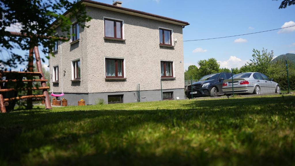 a house with two cars parked in front of it at Pokoje Green House in Ustroń