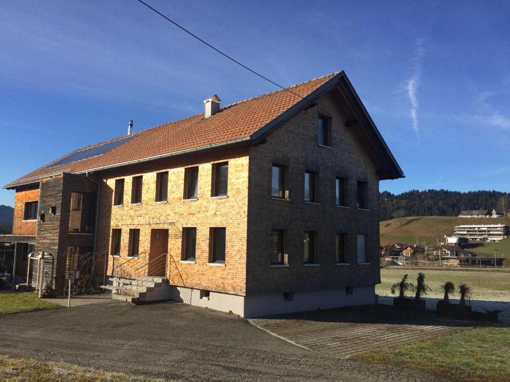 un gran edificio de ladrillo con muchas ventanas en Haus Marie en Alberschwende