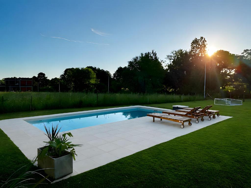 a swimming pool with benches and a soccer ball at Casaquinta overlooking the golf course in Concepción del Uruguay