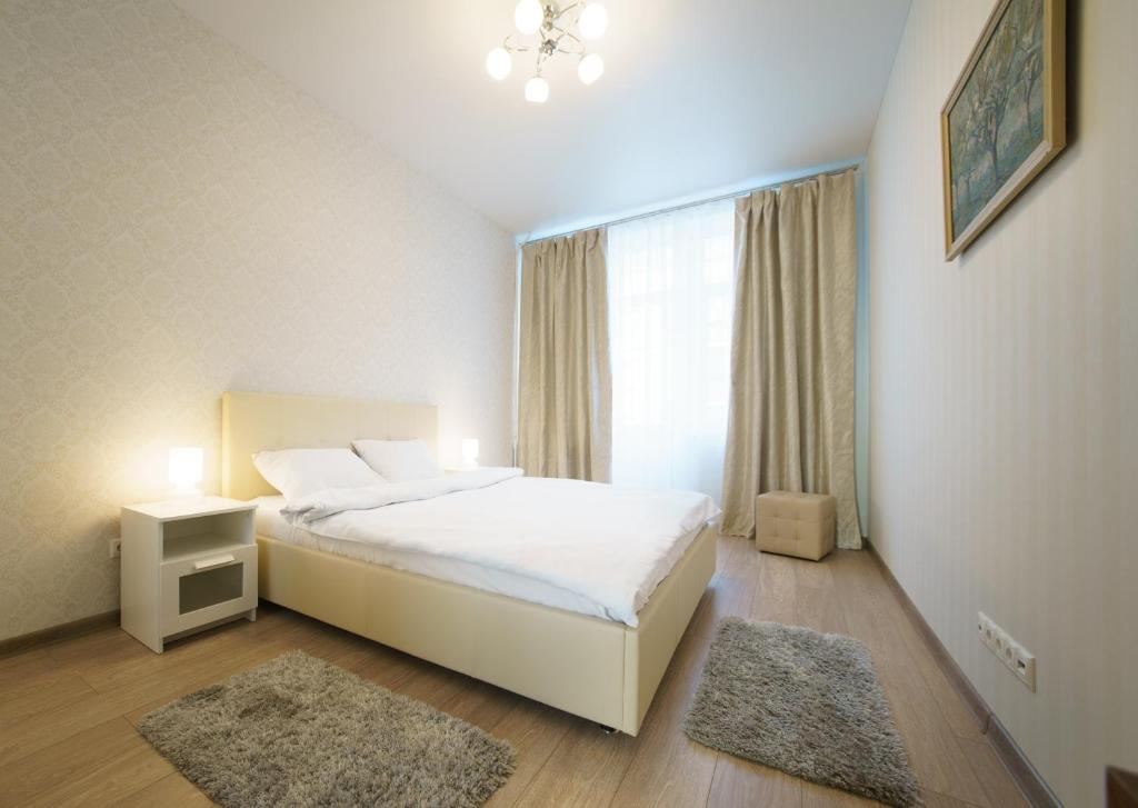 a bedroom with a white bed and a window at PaulMarie Apartments on Mayakovskogo 24 in Brest