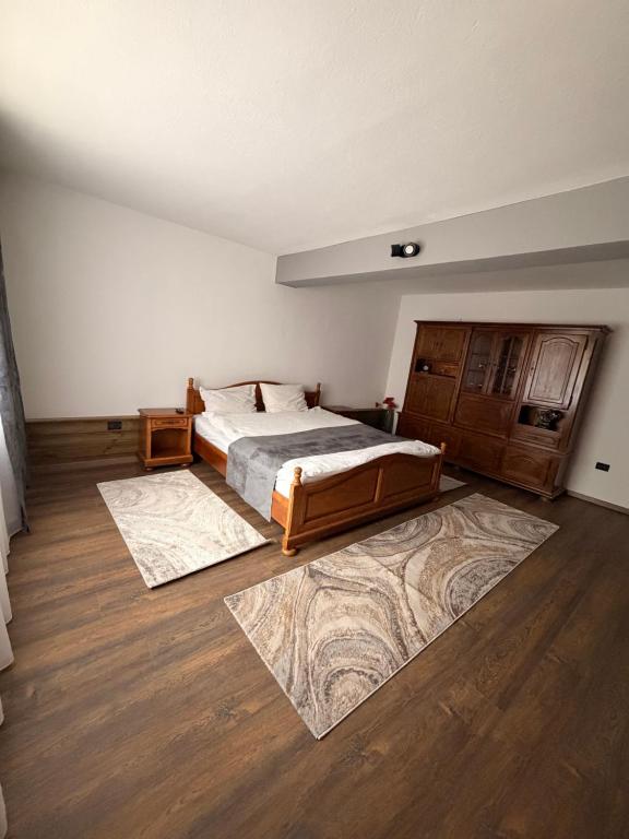 a bedroom with a bed and two rugs on the floor at CozyCloud in Poiana Mărului