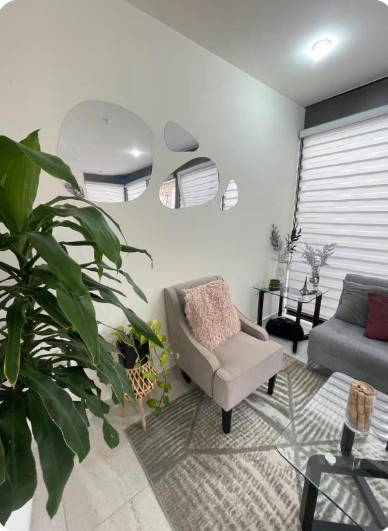 a living room with a chair and a couch at Comfortable, equipped house for long stays in Juriquilla