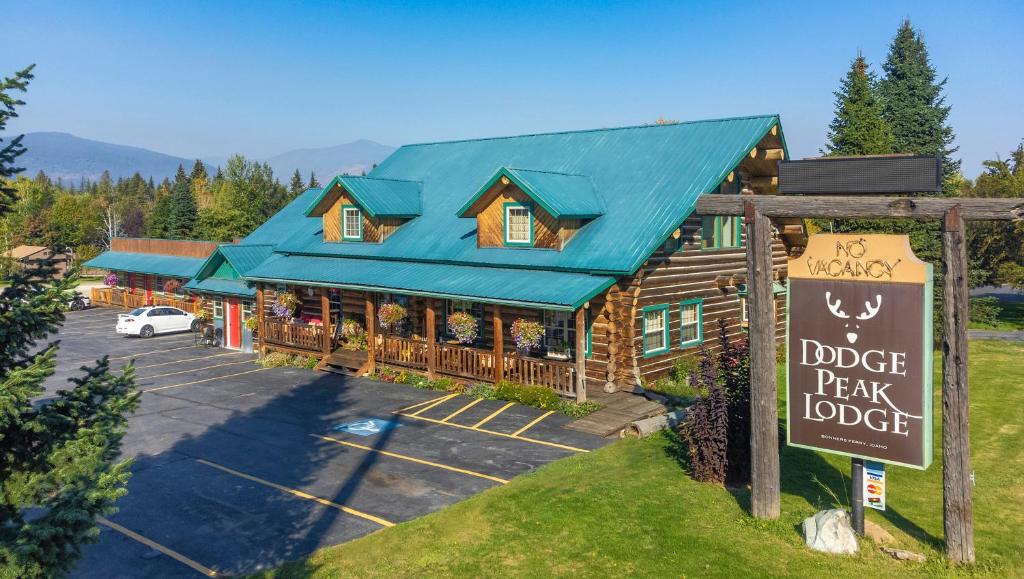 a lodge with a sign in front of a parking lot at Dodge Peak Lodge in Bonners Ferry