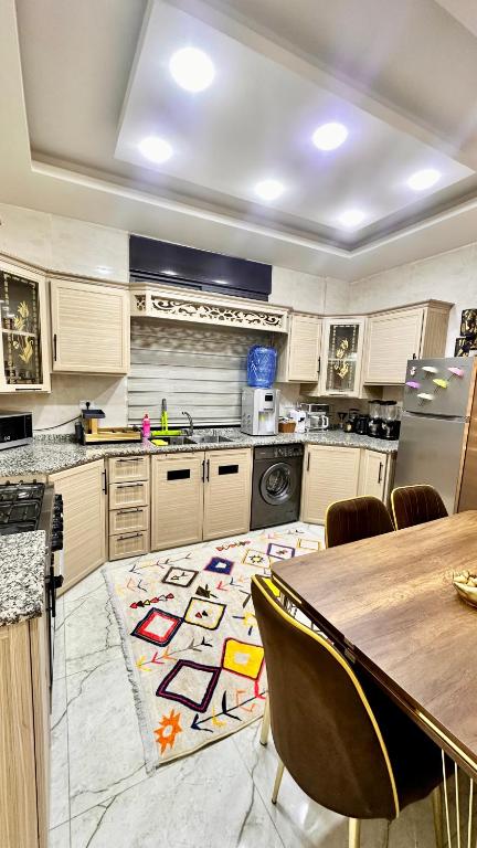 a large kitchen with a table and a kitchen with a rug at مدينة الشرق الزرقاء in Az Zarqa
