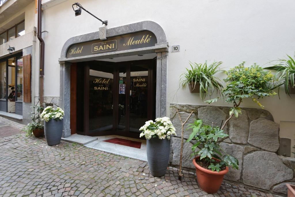 a entrance to a shop with potted plants in front at Hotel Saini with Air conditioning in Stresa