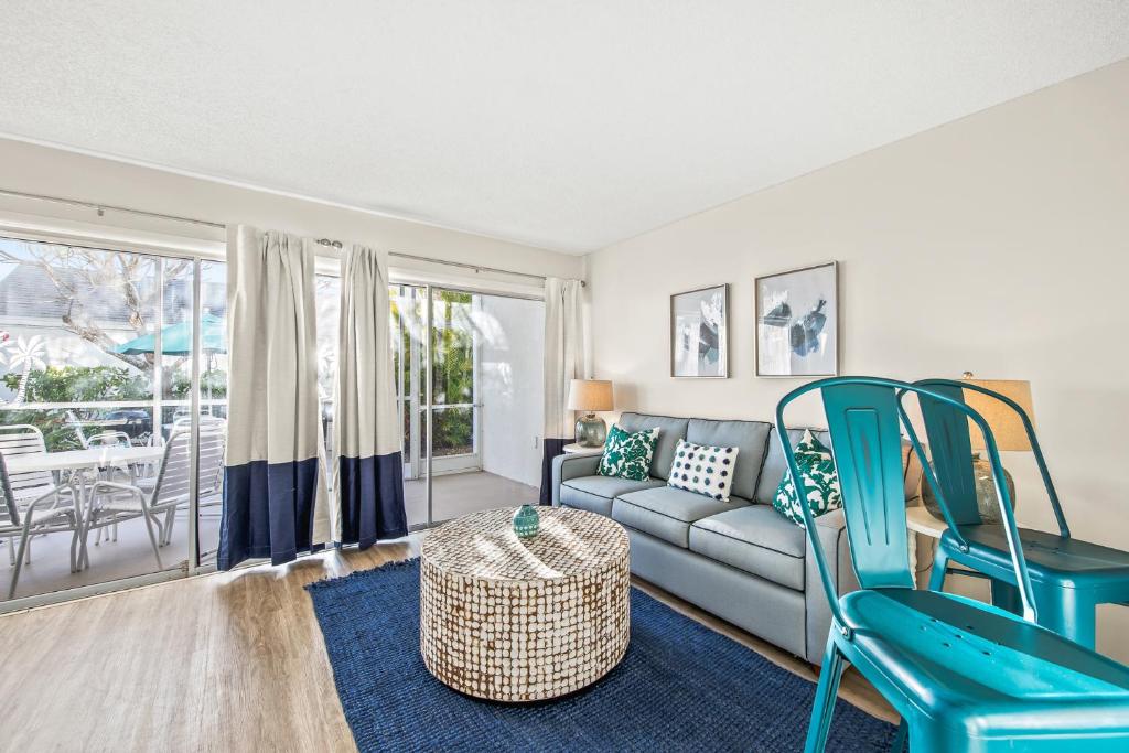 a living room with a couch and chairs at Coconuts Poolside #115 in Holmes Beach