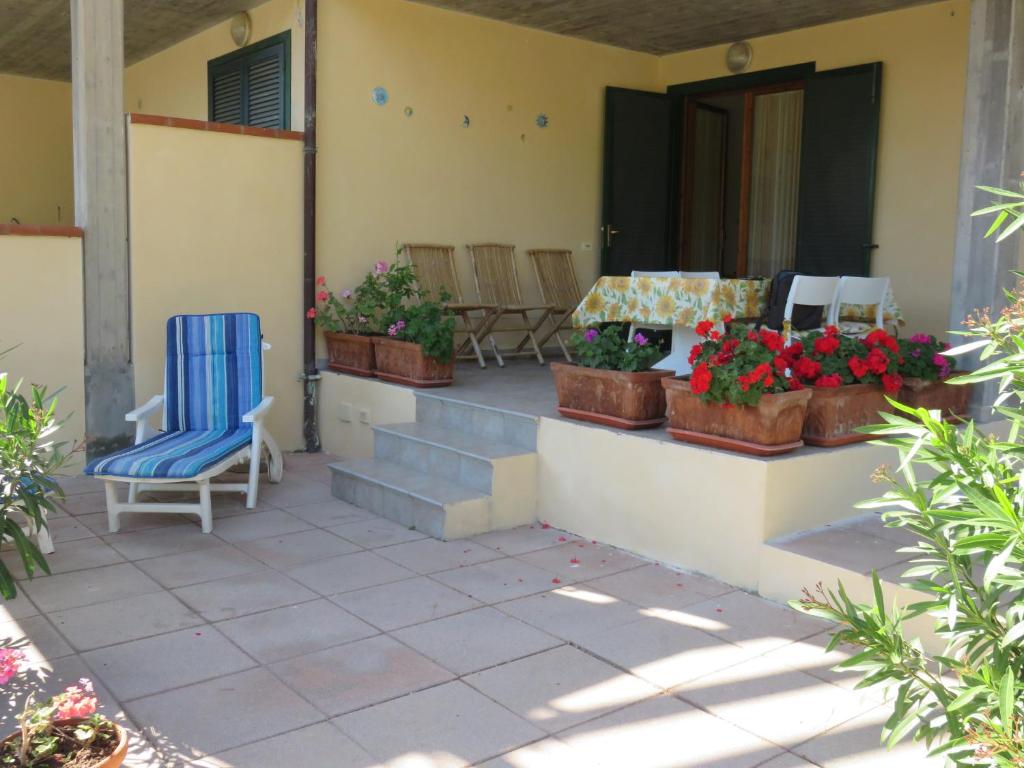 a patio with a blue chair and potted plants at Gli Oleandri in Capoliveri