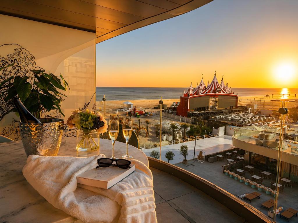 a room with a table with a book and wine glasses at FIRST RESIDENCe in Mamaia