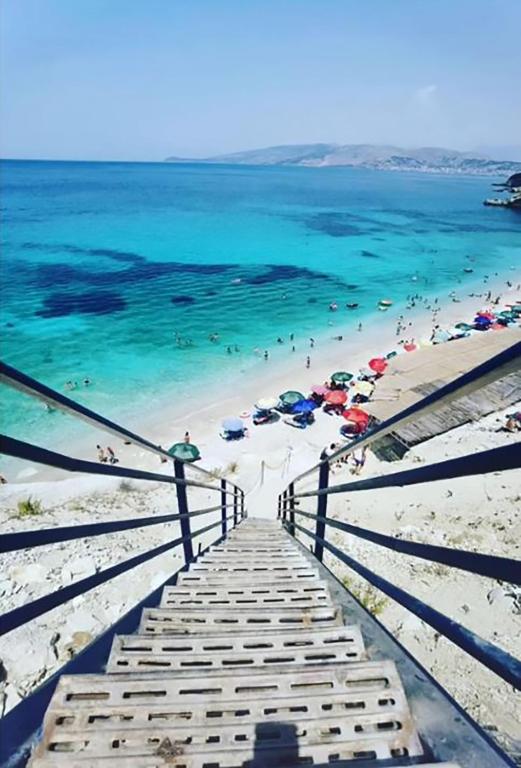 a view of a beach with people in the water at Pigeon Cave Apartments in Ksamil