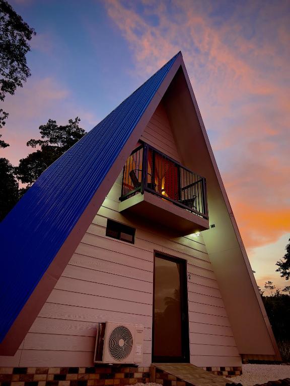 a house with a gambrel roof with a balcony at Cabañas Rio Brazo in Rio Celeste