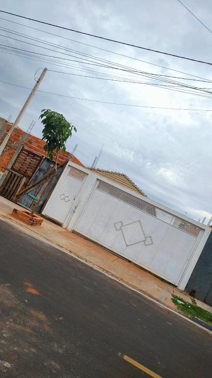 a large white building on the side of a street at Casa Aconchegante S8km do parque do peão in Barretos