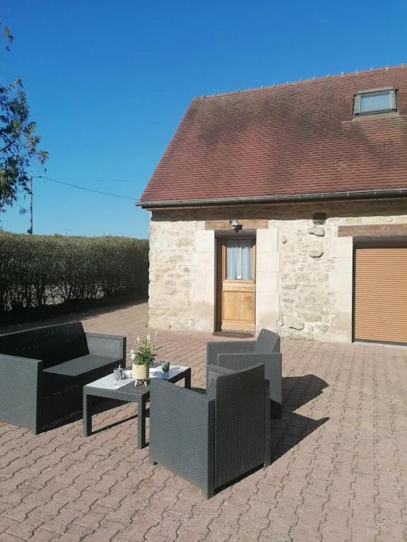 a patio with couches and a table in front of a building at Le Petit Moulin de Verberie in Verberie