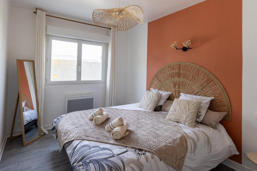 a bedroom with a bed with two stuffed animals on it at Le Cadélac - appartement centre ville cosy in Loudéac