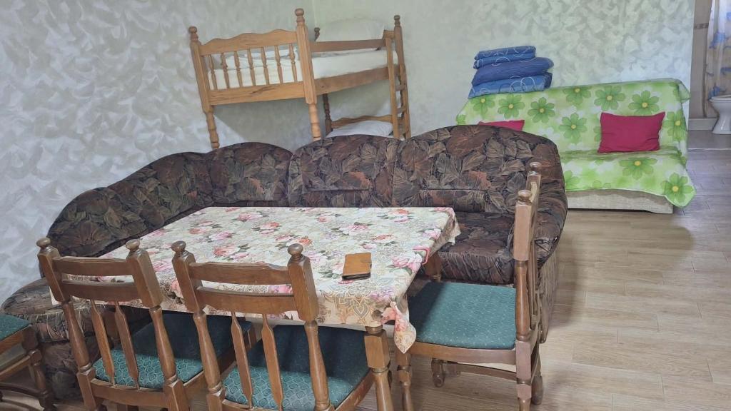 a living room with a couch and a table and chairs at Kuća Vranića,Sevojno in Ðurovići
