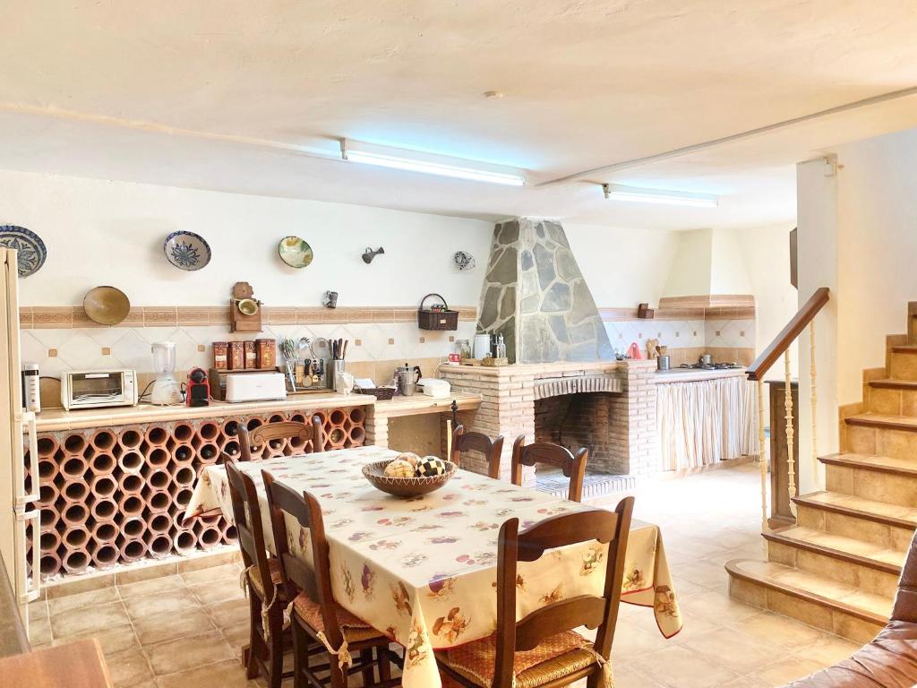 a kitchen and dining room with a table and a fireplace at Villa Nadimar - Casa rural con terraza magnífica y 4 habitaciones in Benecid