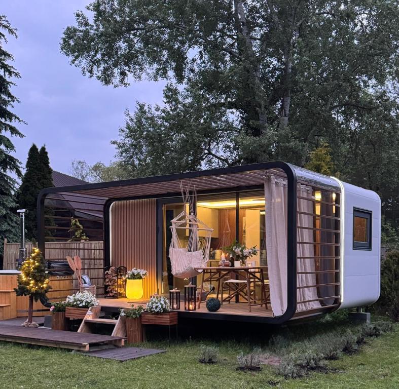 a tiny house with awning in a yard at Zakątek Młynarza in Pruszkowo
