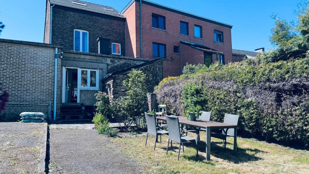 a table and chairs in front of a house at Le refuge de Boncelles in Seraing
