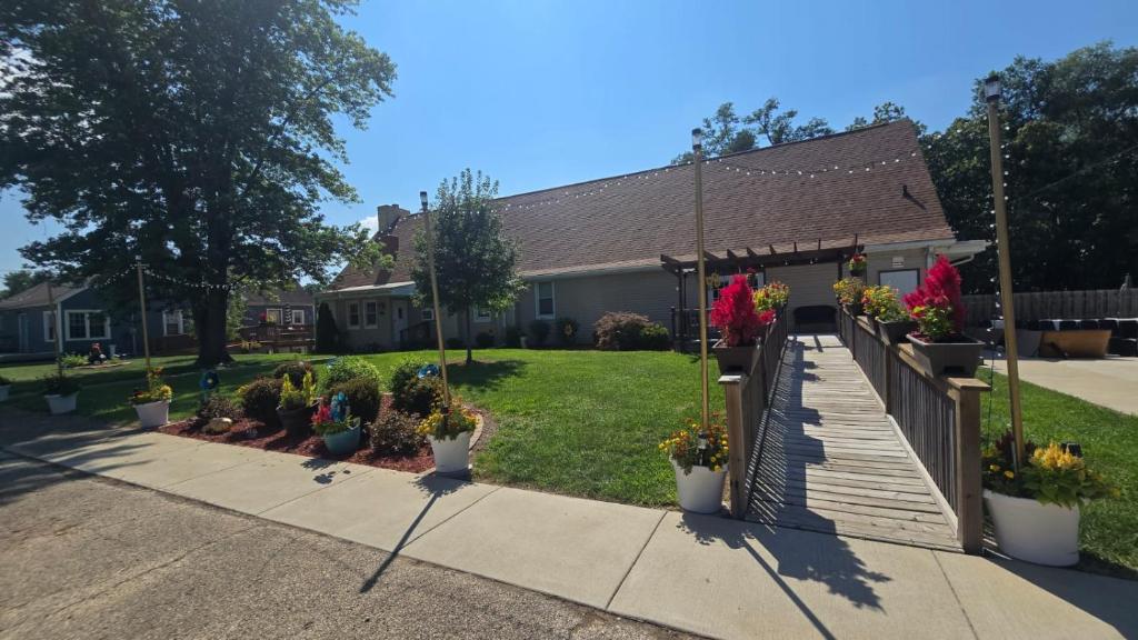 a house with potted plants in front of a yard at Medley Manor in East Peoria