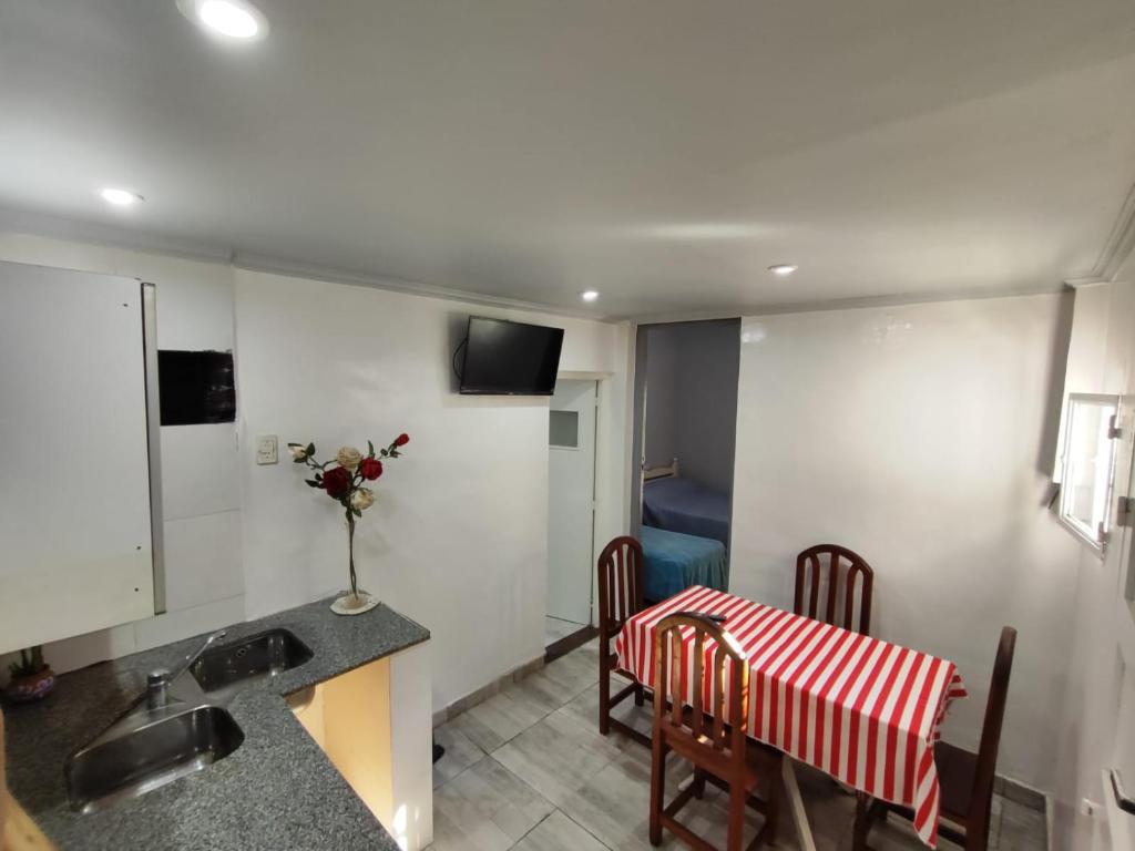 a kitchen with a table and chairs and a sink at Depto Pringles 1740 PB Parking Privado Gratis in Yerba Buena