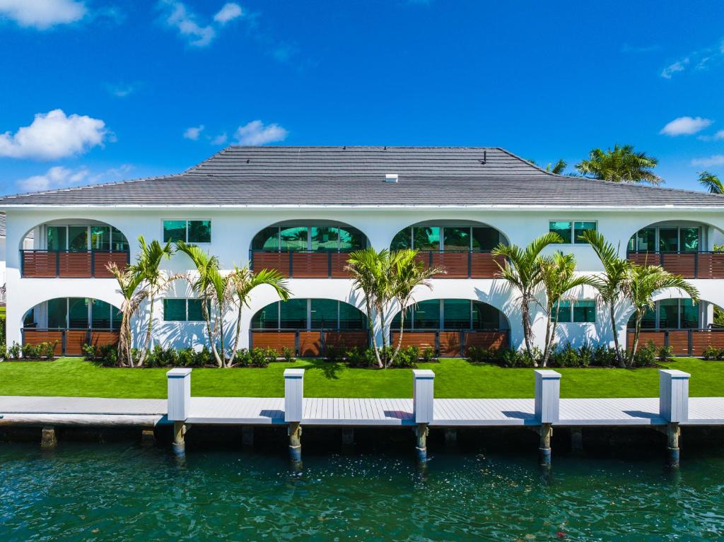 a house on the water with a dock at The Courtyard - Poolside Suite in Boca in Boca Raton