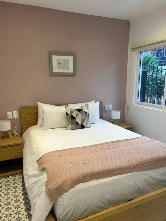 a bedroom with a large bed with a window at Casa Andres in Guadalajara