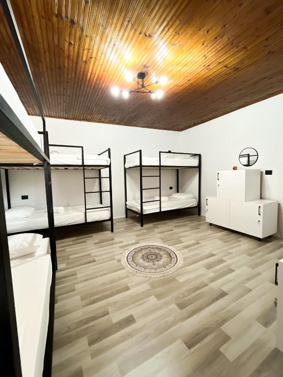 a room with two bunk beds and a wooden ceiling at Hub 1001 Berat Hostel in Berat