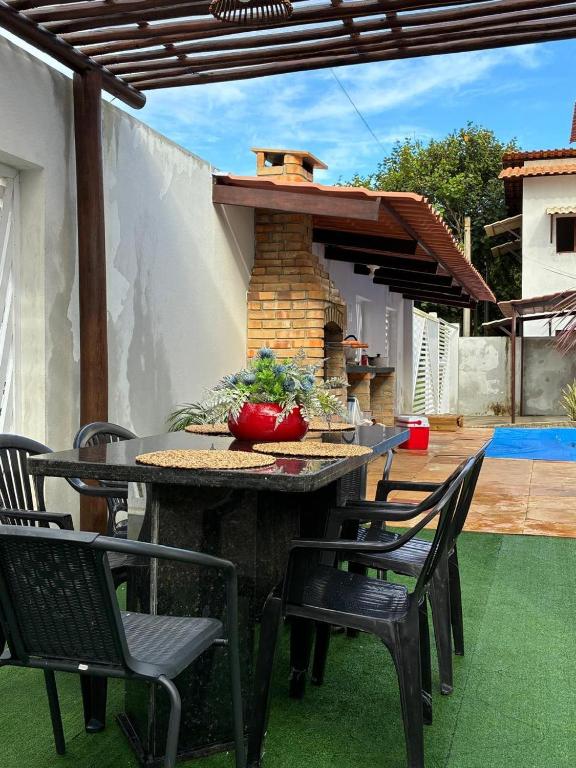a patio with a table and chairs and a brick oven at Casa Flora & Mar in Pipa
