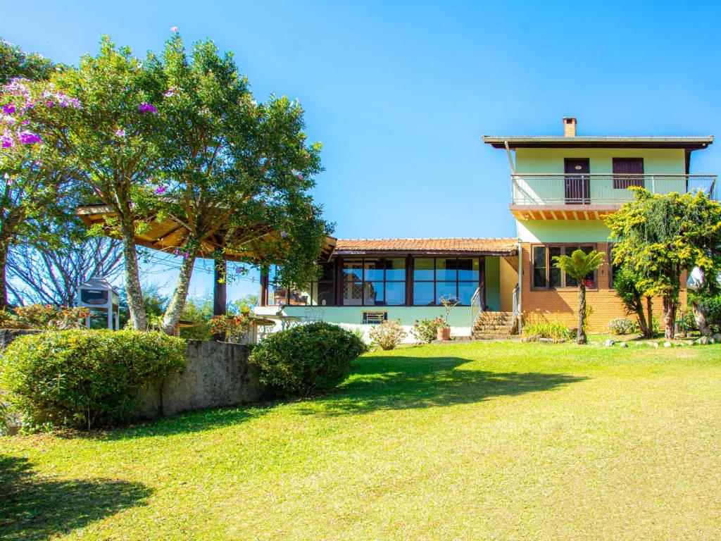 a house with a yard in front of it at Villa da Vila Montanhas in Monte Verde