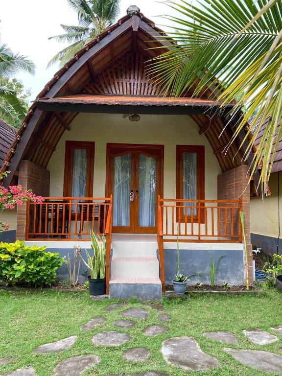 a small house with a porch and a door at Griya Garden Penida in Nusa Penida