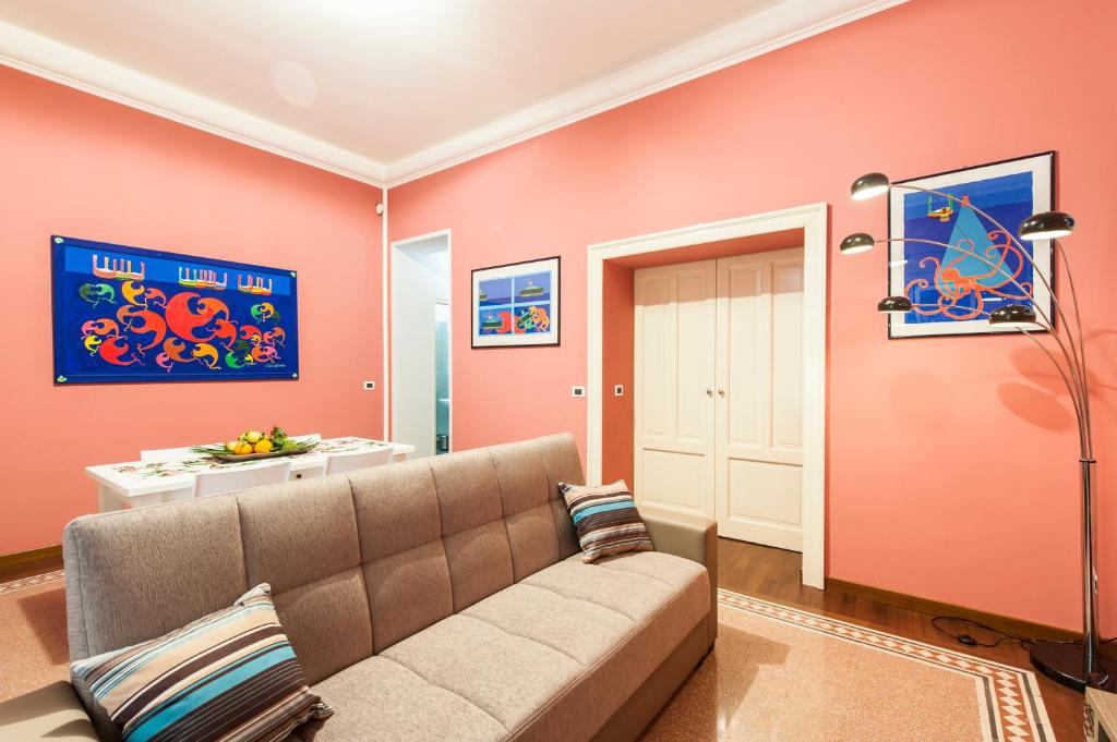 een woonkamer met een bank en roze muren bij Rabbad Apartments in Palermo