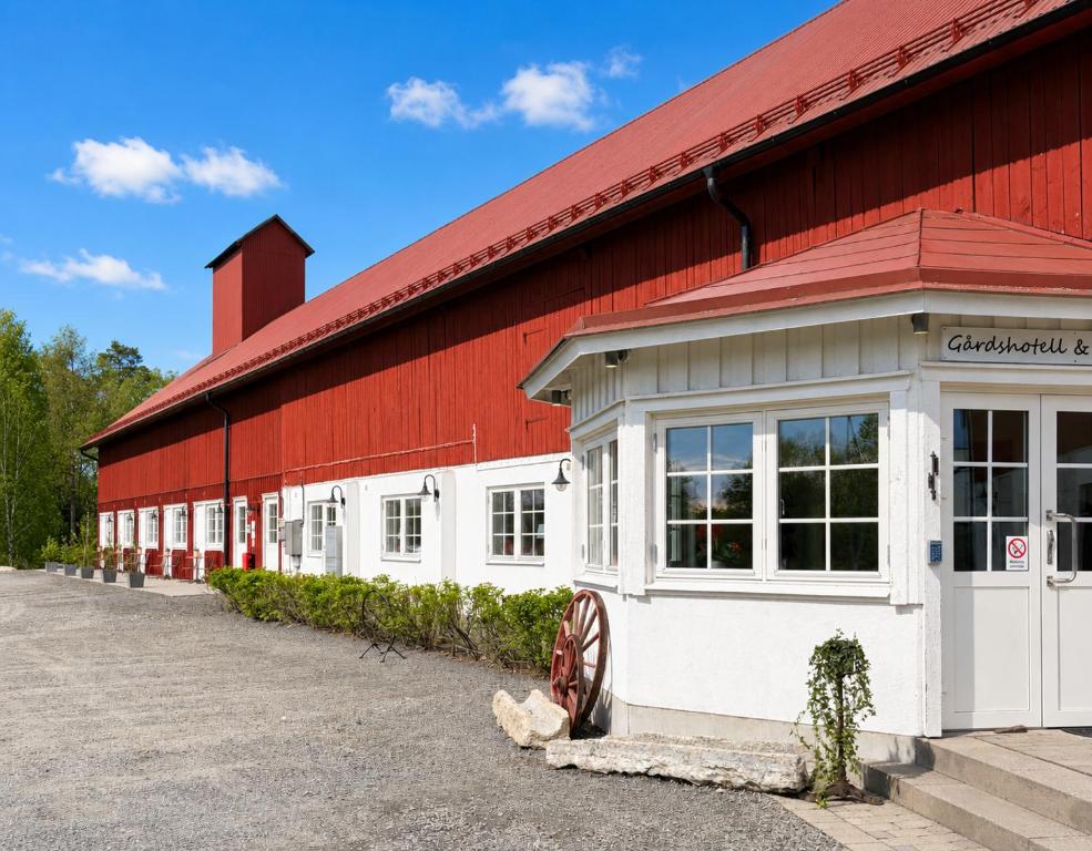 a red and white barn with a red roof at Närebo Gårdshotell in Lidköping